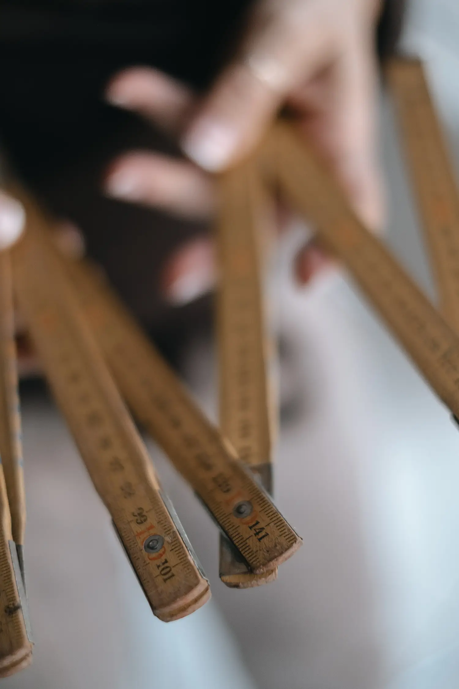 Stefania Luraghi's hands hold a carpenter's tape measure, symbolizing her interior design work.