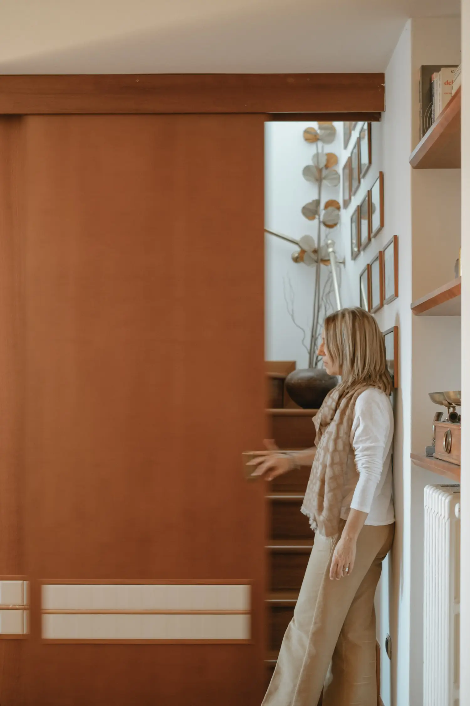 Stefania Luraghi, founder of studio Elles Interior Design , is pictured standing in front of a sliding partition panel she designed.