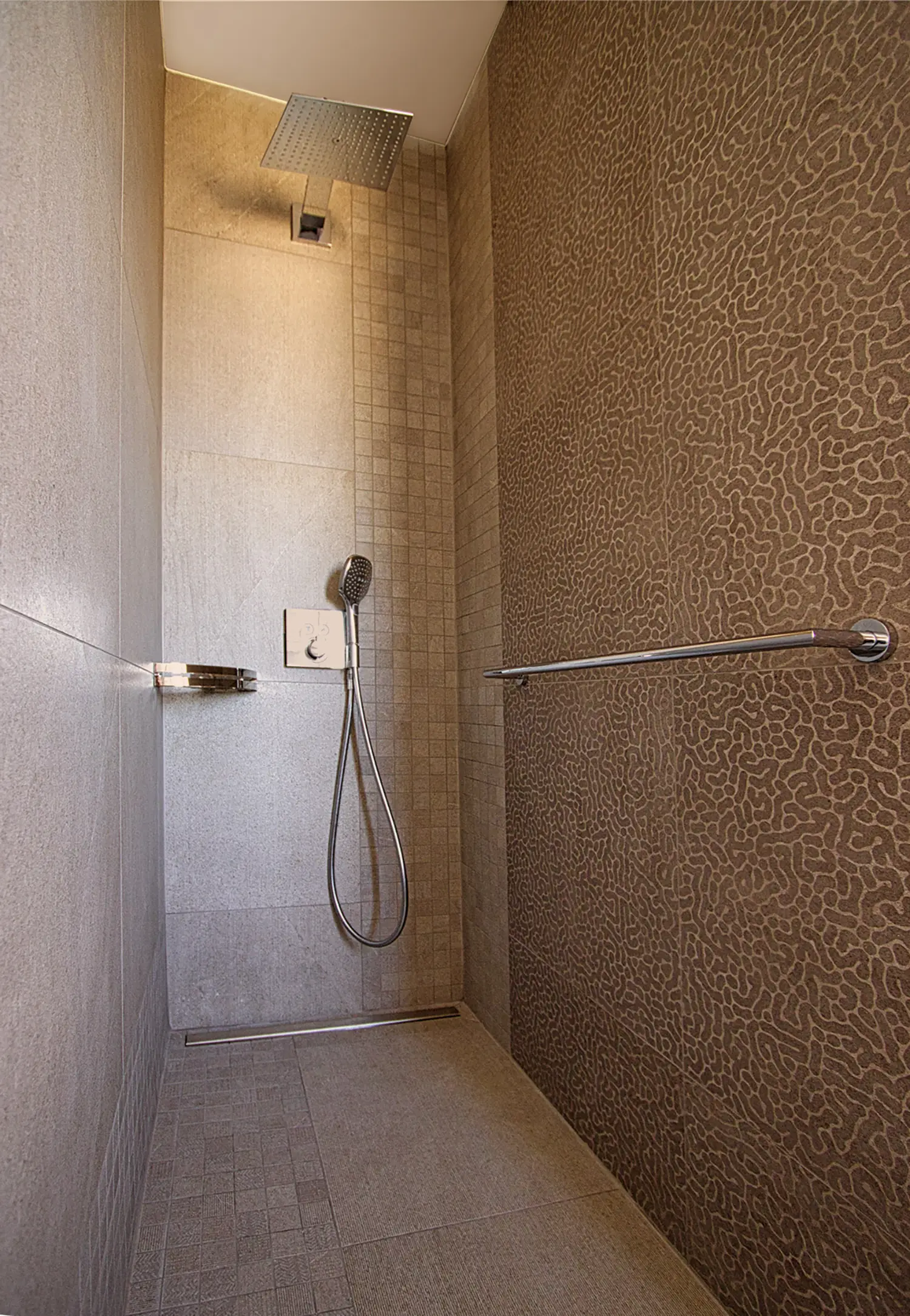 Photo de la douche avec les détails du calepinage des carreaux de faïence dans les tons gris ; projet de rénovation par le studio Elles Interior Design.