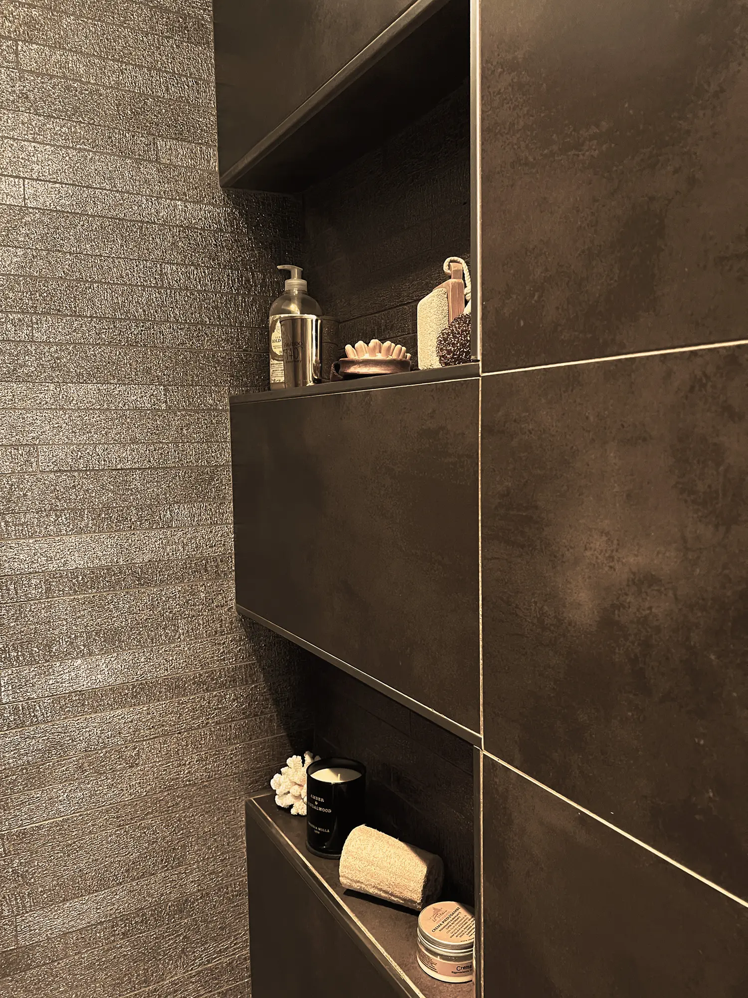 Photo de la douche avec le sol et les revêtements muraux en céramique brune et le détail des niches ; rénovation par le studio Elles Interior Design.