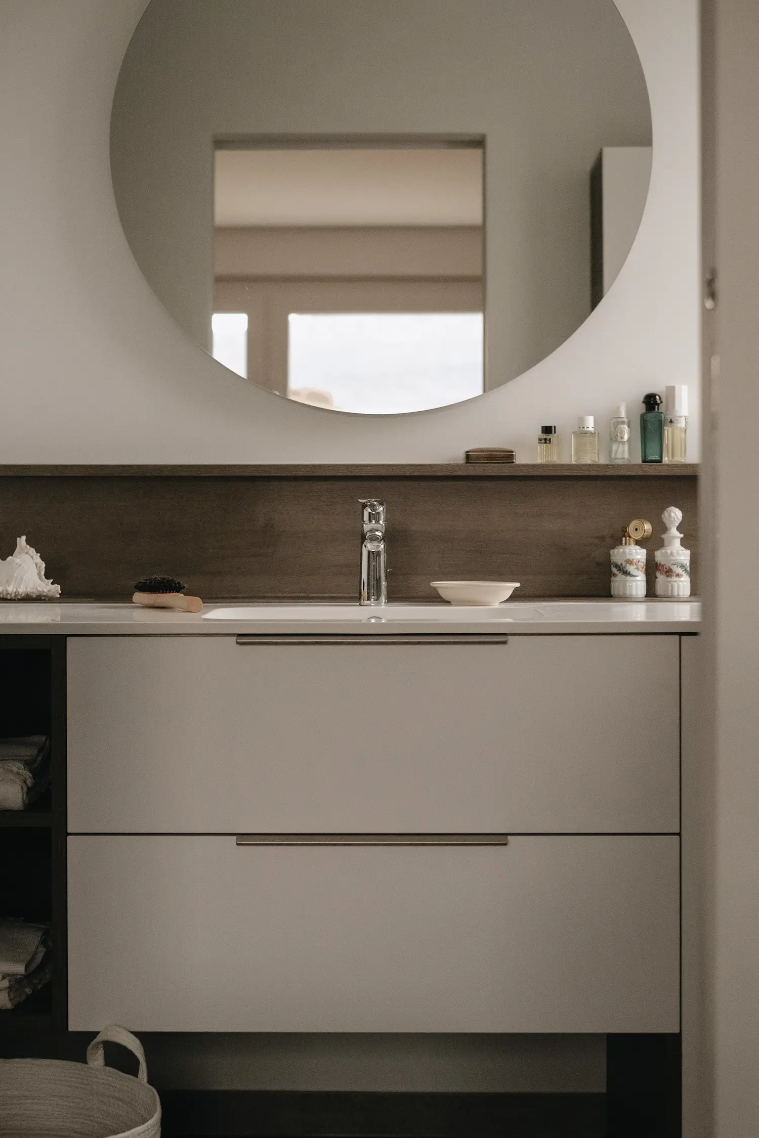 Photo d'ensemble de la salle de bain dans les mêmes tons de blanc et de bois utilisés pour la cuisine afin de créer un lien harmonieux ; projet de rénovation par Elles Interior Design studio.