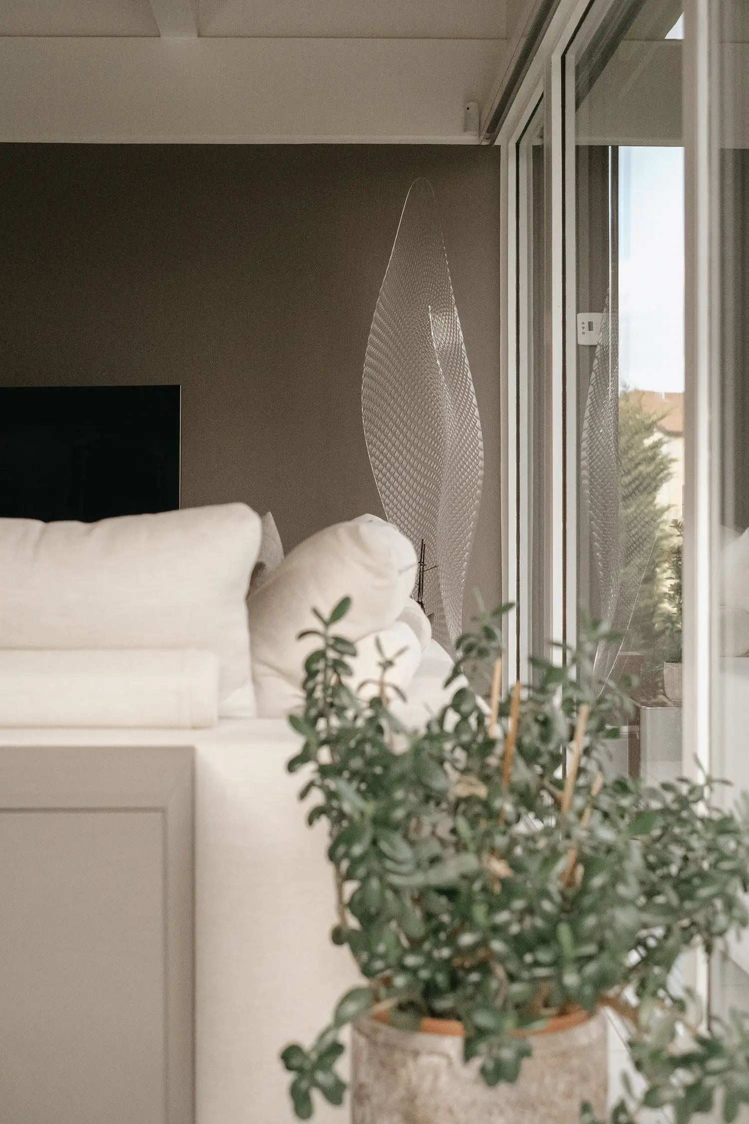 Photo du dossier du canapé avec détails sur la couleur des murs et du lampadaire d'Artemide ; projet de rénovation par le studio Elles Interior Design.