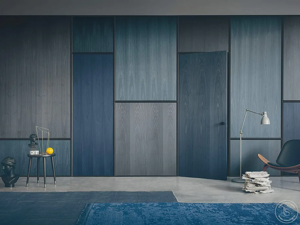 Porte affleurante intégrée dans la boiserie, avec une finition assortie aux murs pour un effet uniforme et raffiné.