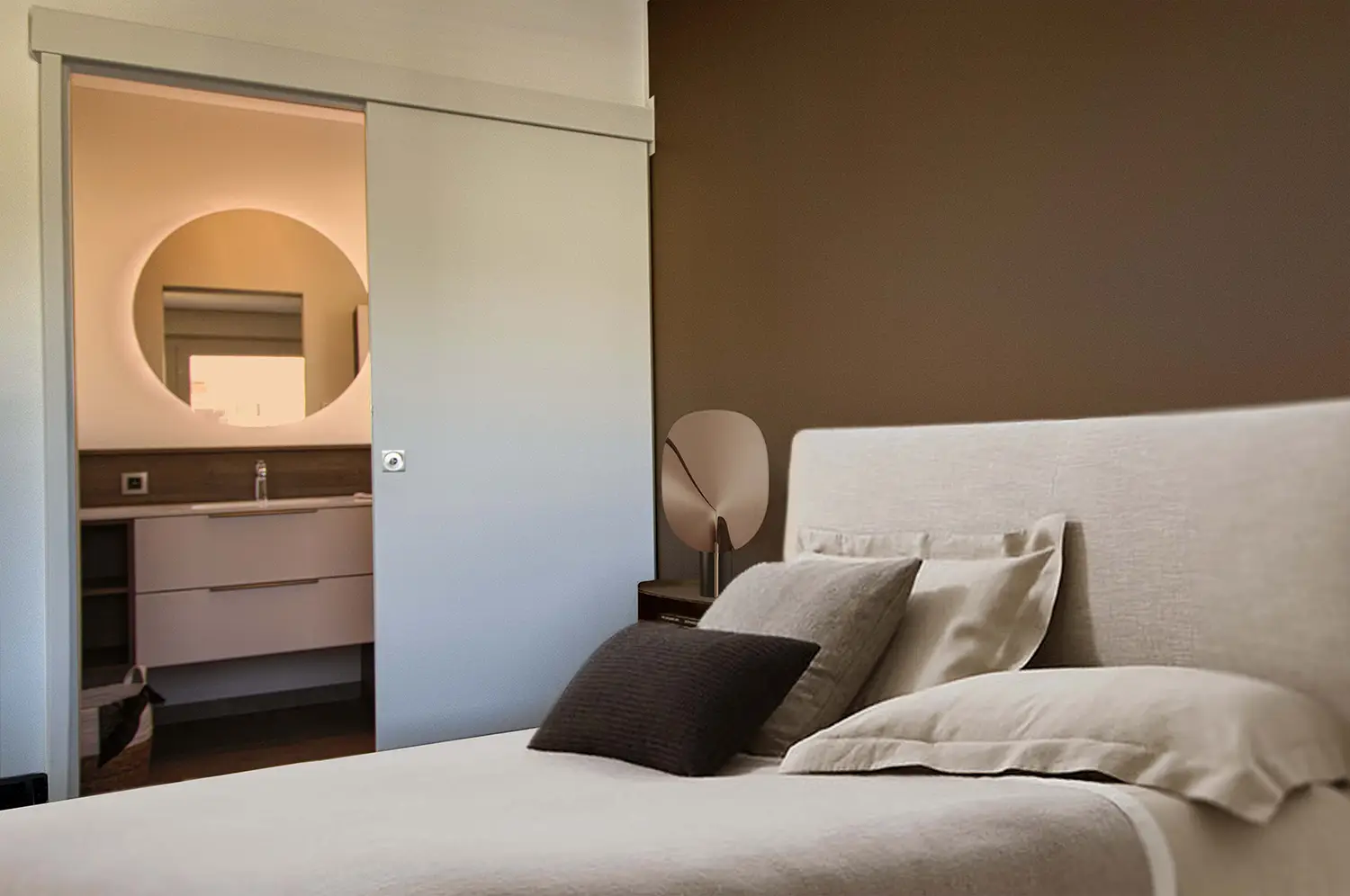 Foto camera da letto con parete color cioccolato e sullo sfondo il bagno adiacente; progetto di ristrutturazione dello studio Elles Interior Design