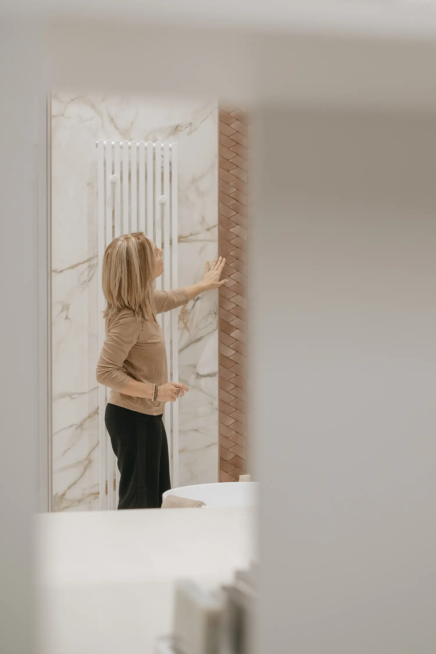 La designer di home interior Stefania Luraghi mentre verifica la posa di un rivestimento in ceramica, all'interno di un cantiere.