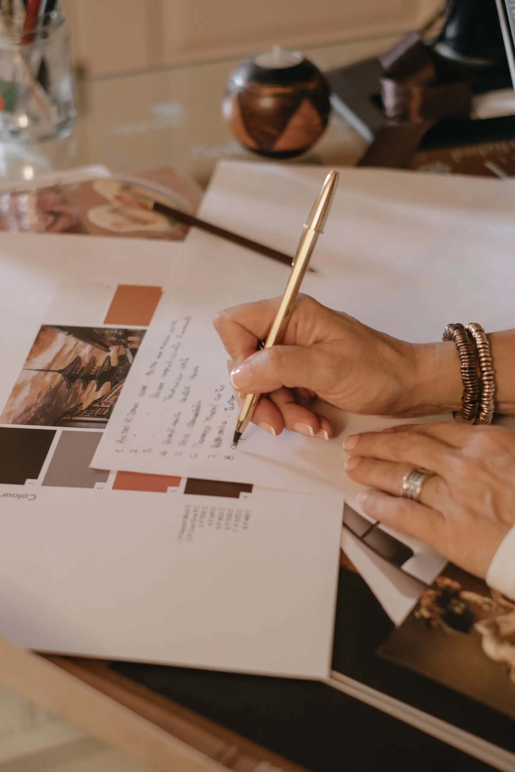 Dettaglio della mano dell'interior designer Stefania Luraghi, titolare dello studio Elles Interior Design, mentre prende appunti.